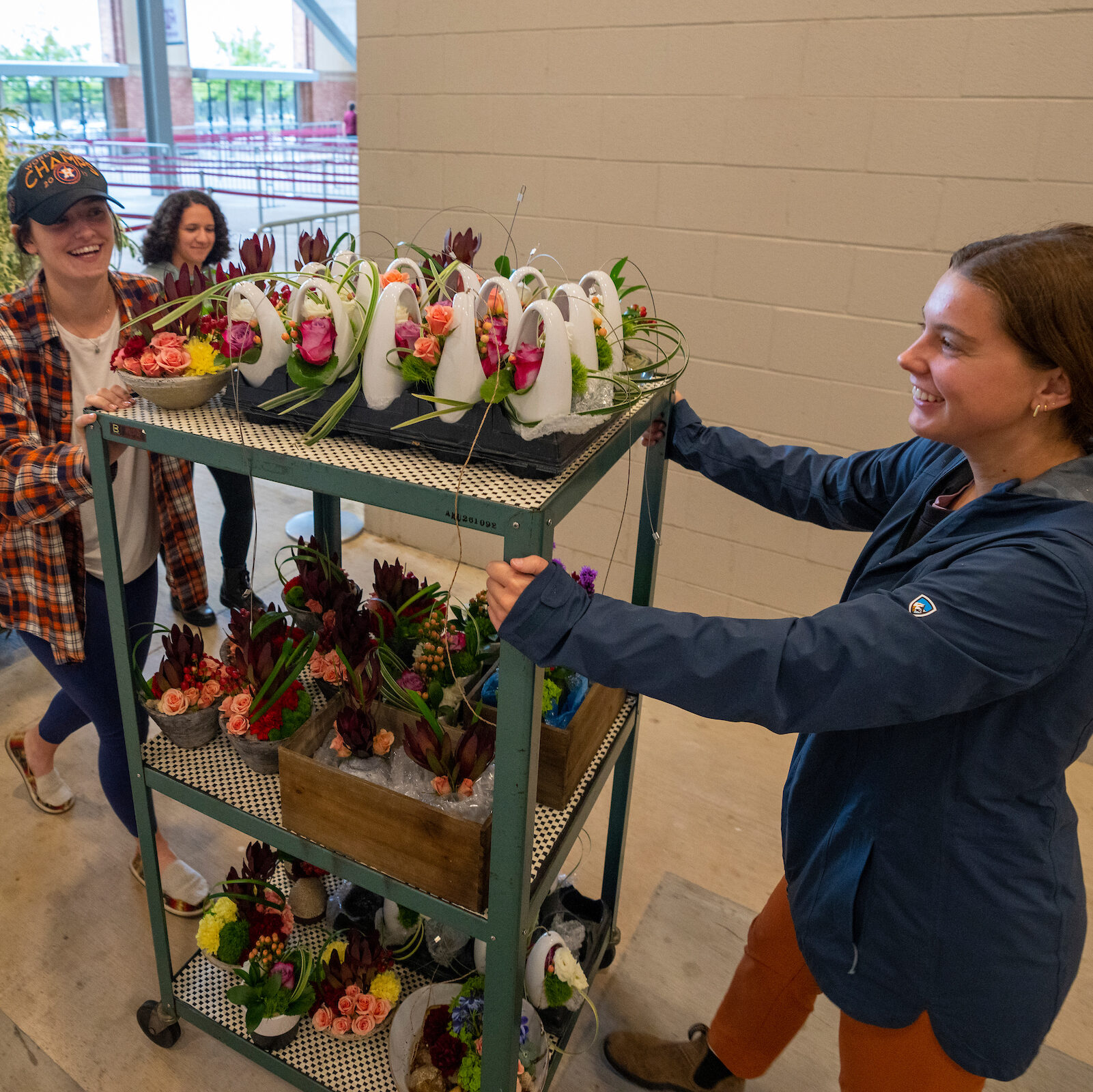 Students pushing a cart with floral arrangements.