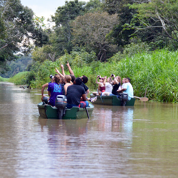Students in a kayak floating down a river.